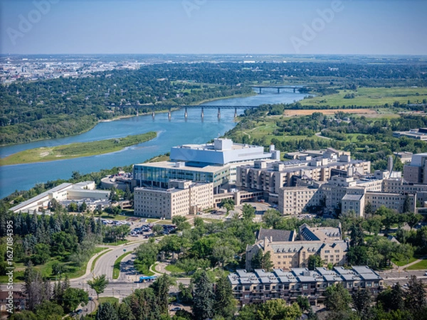 Fototapeta City view with a river running through it and a large hospital in the middle