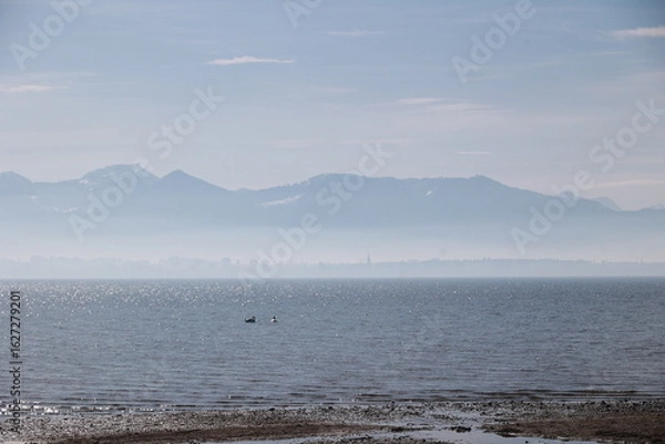 Obraz A calm body of water with a few birds flying over it