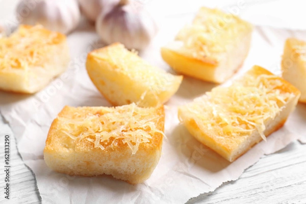 Fototapeta Tasty bread slices with garlic and cheese on paper