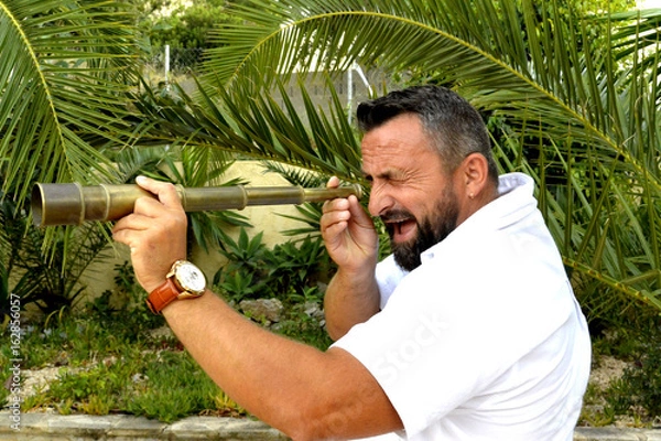 Fototapeta A man with spyglass