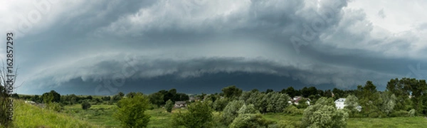 Obraz Approaching supercell thunderstorm in the village, panorama of the storm clouds