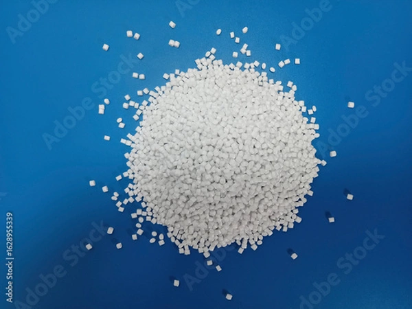 Fototapeta plastic masterbatch, white masterbatch granules as virgin polymer resin pigment, poured into blue background media, suitable for industrial plastic company profile product catalog design