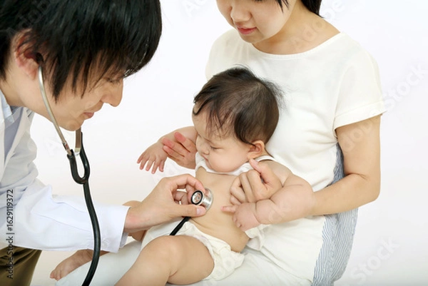 Fototapeta お母さんに抱かれ、聴診器で診察される赤ちゃん
