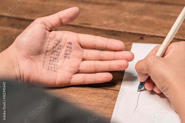 Obraz People cheating on test by writing answer on hand