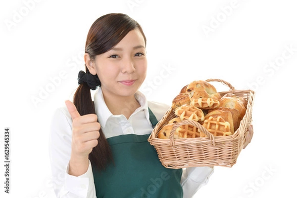 Obraz パンを持つエプロン姿の女性