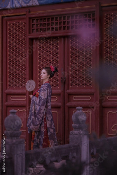 Fototapeta Traditional attire with elegant pose and fan Chinese word means beauty.