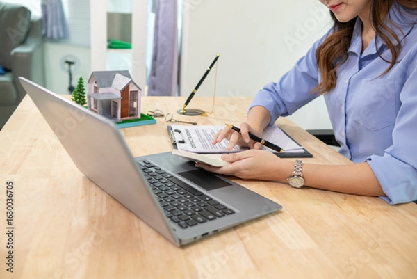 Fototapeta Real estate businessman or broker is calculating interest rate based on the period of time that the client wants to use in deciding to make a contract to buy a real estate. Real estate trading concept