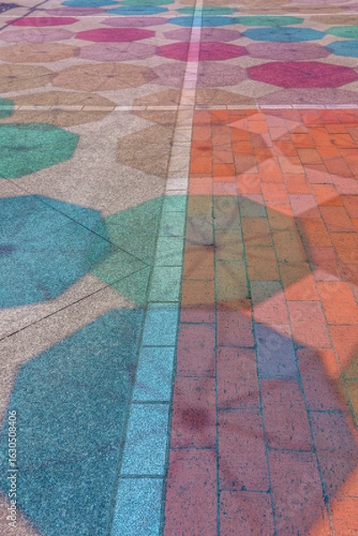 Obraz 夏の晴れた日に、地面に映る色とりどりの傘の影