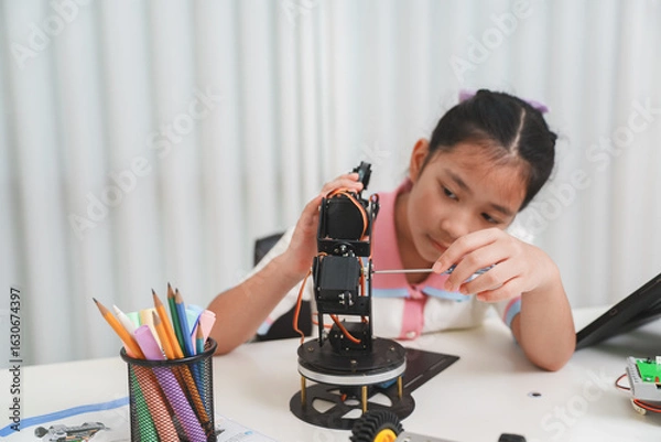 Fototapeta A child focused on building an electronic robot.