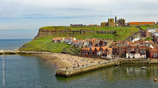 Fototapeta View across the harbor of the east cliff of the popular tourist town of Whitby in North Yorkshire, England