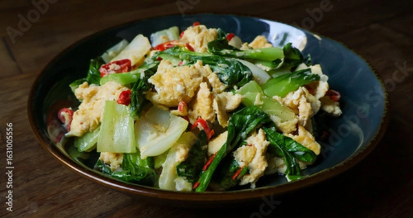 Fototapeta Stir-fried bok choy or pak choy with scrambled eggs, showcasing vibrant green and golden colors. Healthy cooking, Asian cuisine, food blogs, and recipe illustrations. Close up
