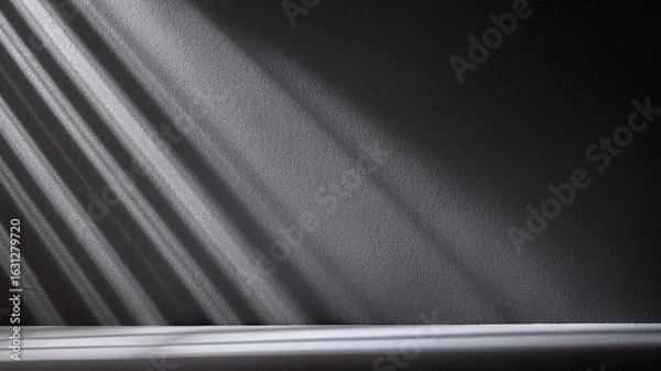 Fototapeta High contrast black and white wall with strong light and shadow play. Bold modern style.