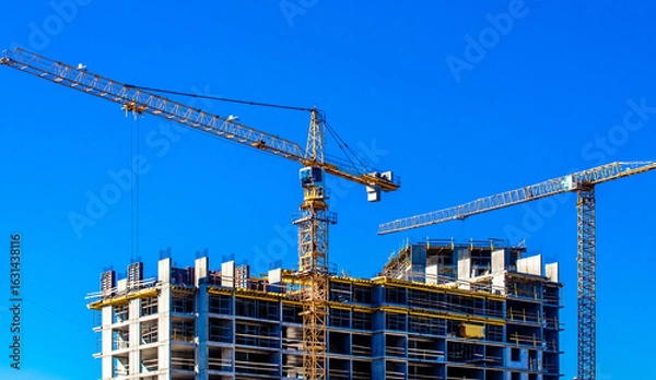 Fototapeta construction cranes are building a house
