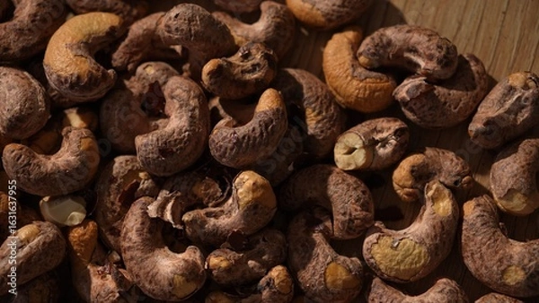 Fototapeta Top view of raw cashew nuts on wooden surface