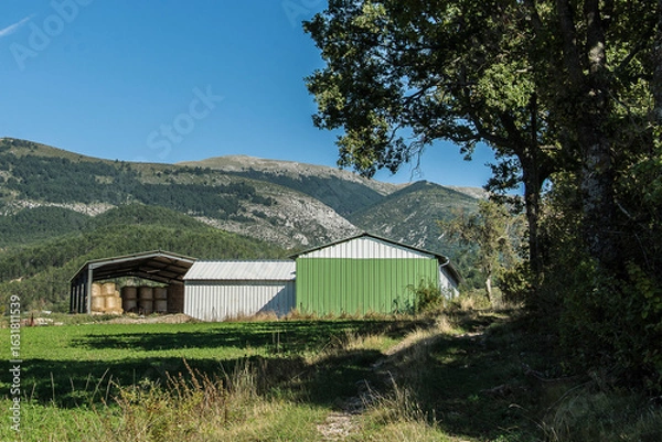 Fototapeta barns of a farm in front of the hills of the French Verdon region