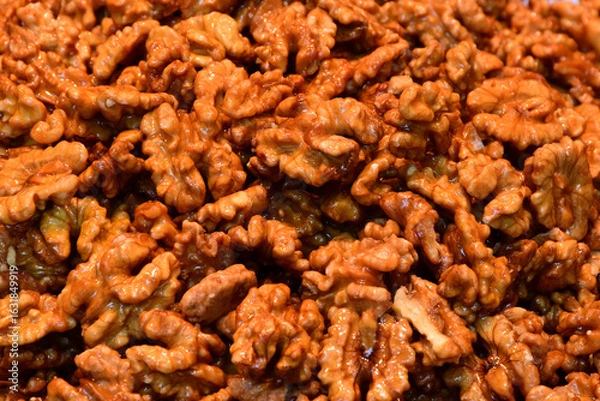 Fototapeta closeup of walnuts with sugar glazed cover or coating. macro view. heap of nuts. food and food ingredients. healthy eating. vegetarian eating. 