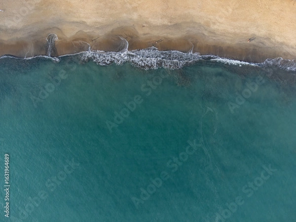 Obraz Wonderful tropical beach with blue water and orange sand forming small waves seen from above