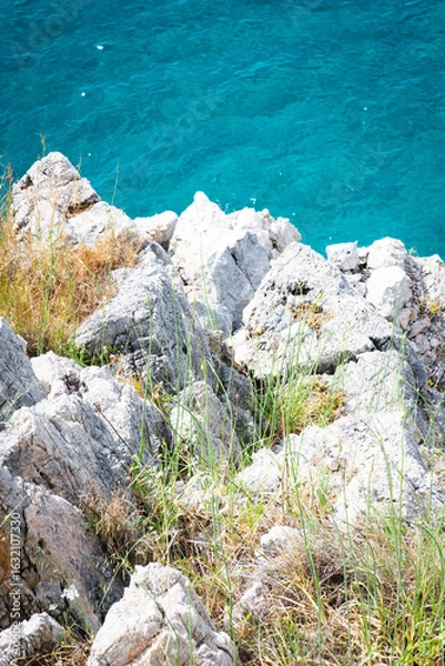 Fototapeta Stunning view of Calella de Palafrugell's pristine coastline featuring traditional whitewashed Mediterranean architecture, crystal-clear turquoise waters, and dramatic rocky outcrops along Costa Brava