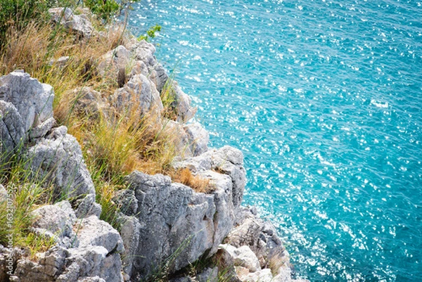 Fototapeta Stunning view of Calella de Palafrugell's pristine coastline featuring traditional whitewashed Mediterranean architecture, crystal-clear turquoise waters, and dramatic rocky outcrops along Costa Brava