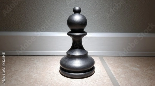 Fototapeta Close-up View of a Glossy Black Chess Pawn Piece on a Light Tile Surface with Shadows and Highlights Captured in Soft Natural Light