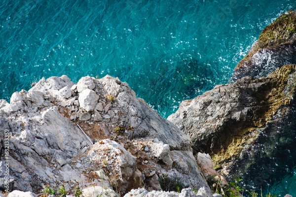 Fototapeta Stunning view of Calella de Palafrugell's pristine coastline featuring traditional whitewashed Mediterranean architecture, crystal-clear turquoise waters, and dramatic rocky outcrops along Costa Brava