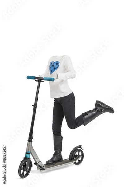 Fototapeta Empty clothes. Little girl with withe shirt and black pants in a scooter.