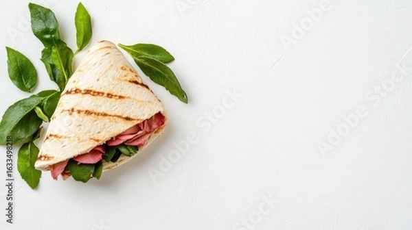 Fototapeta Grilled flatbread sandwich with pink filling and greens