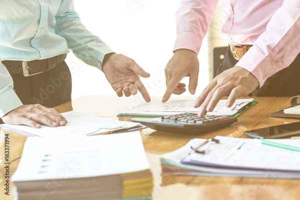 Fototapeta Businessman explaining bar chat to colleagues at conference table