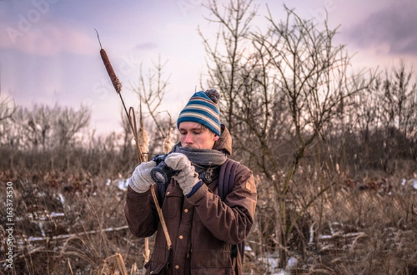 Obraz Photographer in mittens in frost makes photos in nature
