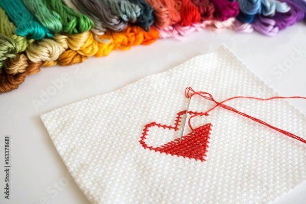 Obraz Stitching red heart shape on white fabric on white background.