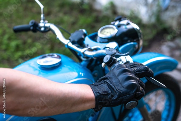 Fototapeta A motorcyclist holds the handlebars of a motorcycle in a motorcycle glove