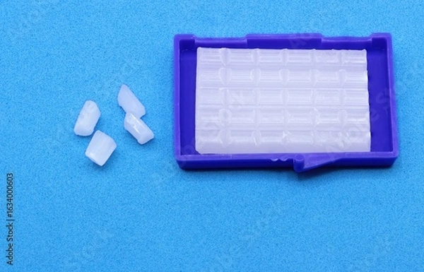 Fototapeta Orthodontic Wax for Braces on Blue Background – Dental Care Concept