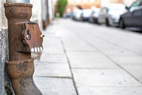 Fototapeta Rusty Drainpipe on Urban Street – Close-Up with Shallow Depth of Field