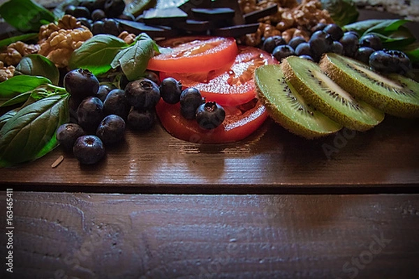 Obraz Some nuts, blueberries, dark chocolate, kiwi and tomatoes that are healthy foods for you body and your brain.
