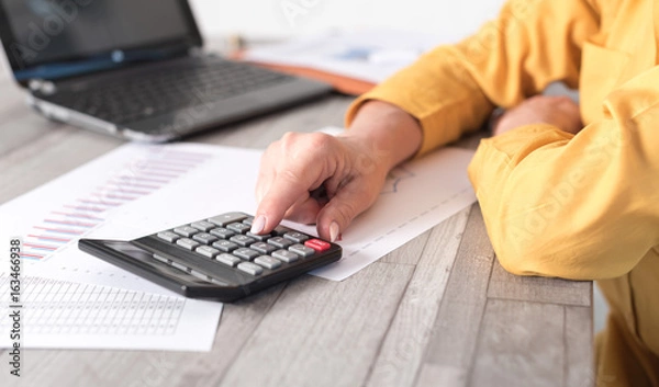 Fototapeta Hands of an accountant working on financial documents