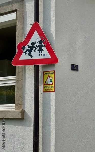 Fototapeta Traffic Warning Sign for Playing Children on Building Wall, Germany