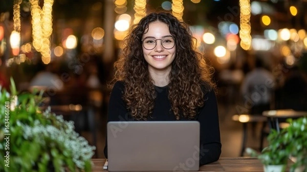 Fototapeta Woman working on laptop with string lights bokeh background