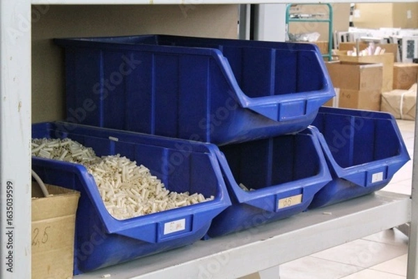 Fototapeta Blue Plastic Storage Bins on Metal Shelf. Several Blue Bins for Parts Organization. Plastic Containers for Storage on Shelving. Blue Industrial Storage Bin Arrangement. Blue Plastic Bins for Inventory