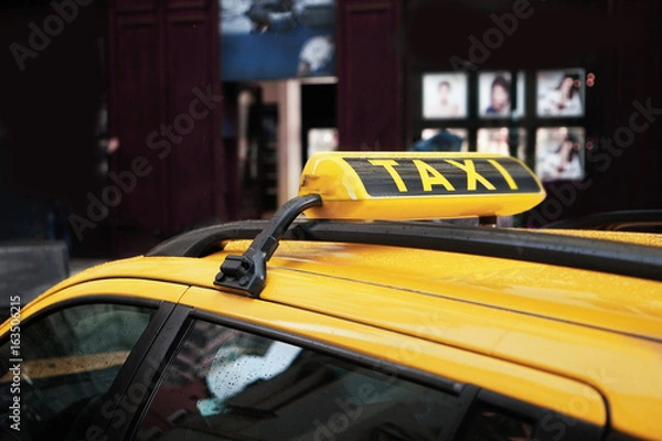 Fototapeta Taxi sign on yellow car roof, closeup