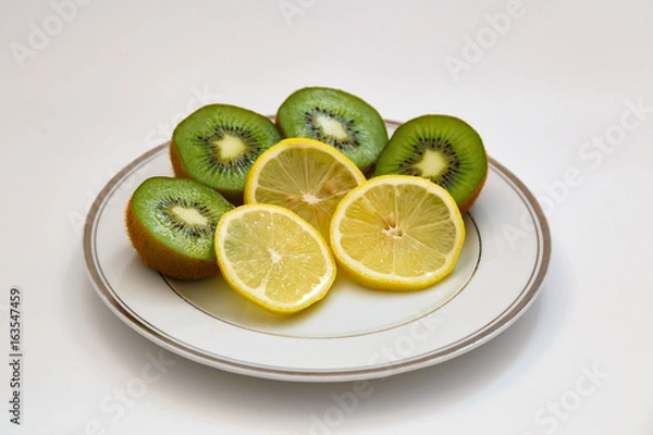 Fototapeta Kiwi and lemon on a white plate