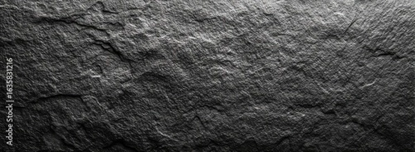 Fototapeta Dark gray stone texture.  Rough, uneven surface with prominent lines and grooves