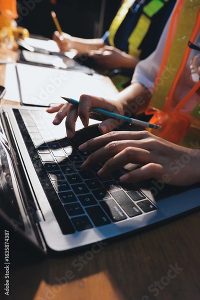 Fototapeta Closeup of team of industrial engineers meeting analyze machinery blueprints consult project on table in manufacturing factory. Working in manufacturing plant or production plant.