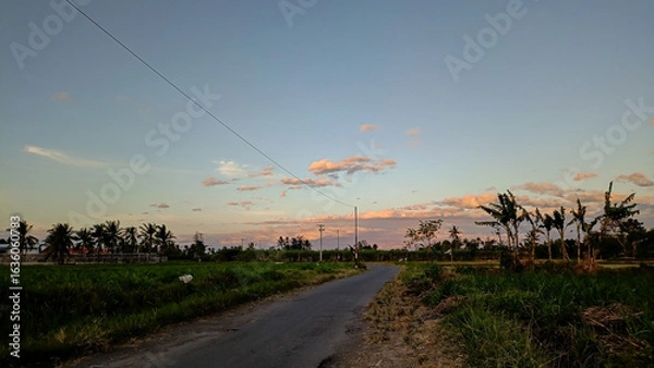Fototapeta What a beautiful view. The streets weren't crowded in the morning. The sun rose in a beautiful orange hue. The blue sky combined with the orange hues created an extraordinary beauty.
