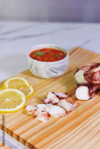 Fototapeta Grilled octopus slices with lemon and dipping sauce