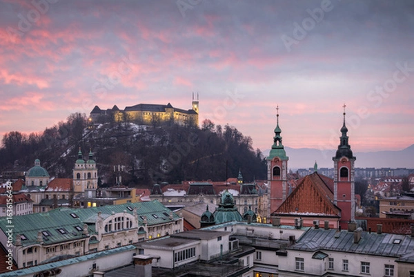 Fototapeta Ljubljana cityscape with castle and cathedral towers under colorful sunrise sky