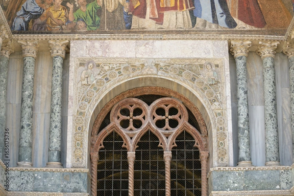 Fototapeta Arched window with twisted columns and sculpted marble decoration on the facade of St. Mark's Basilica (Basilica di San Marco), Venice, Italy.
