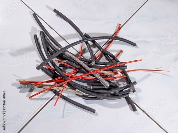 Fototapeta A pile of various types of used electrical cables on the ceramic floor, ready to be recycled.