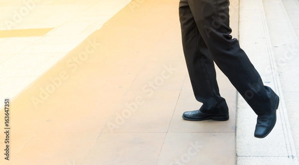 Fototapeta Legs of man step up from steps and forward to space for move for ward and adance concept