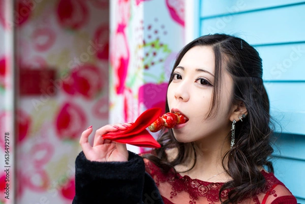 Obraz 都会の路地でいちご飴を食べる日本人女性のポートレート