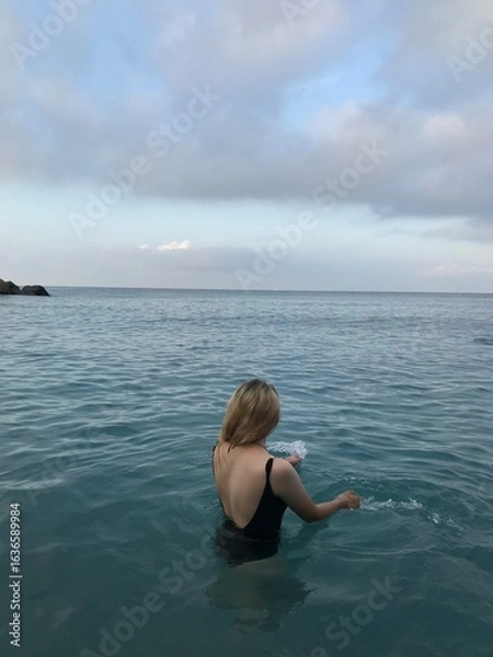 Obraz Female swimmer in turquoise sea under the morning sun.
